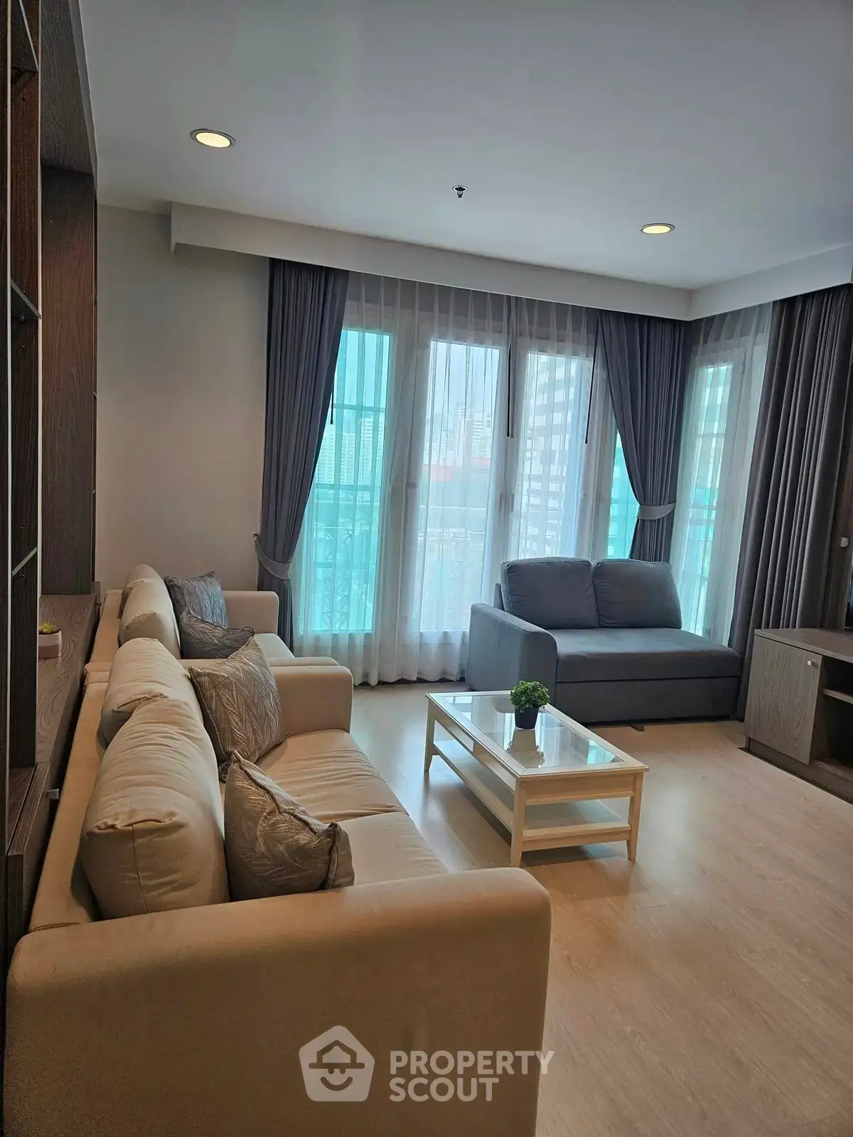 Spacious living room with modern decor and large windows in a stylish apartment.