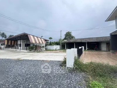 Charming suburban property with spacious driveway and covered parking area.