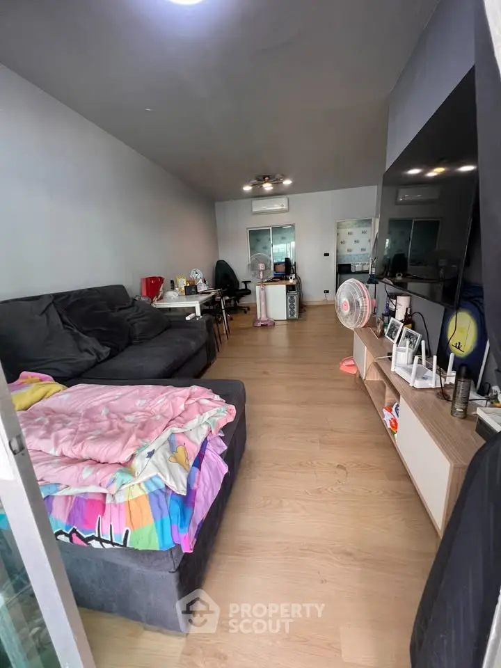 Spacious living room with modern decor and cozy seating area, perfect for relaxation and entertainment.