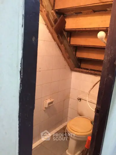 Compact bathroom with sloped ceiling and basic fixtures