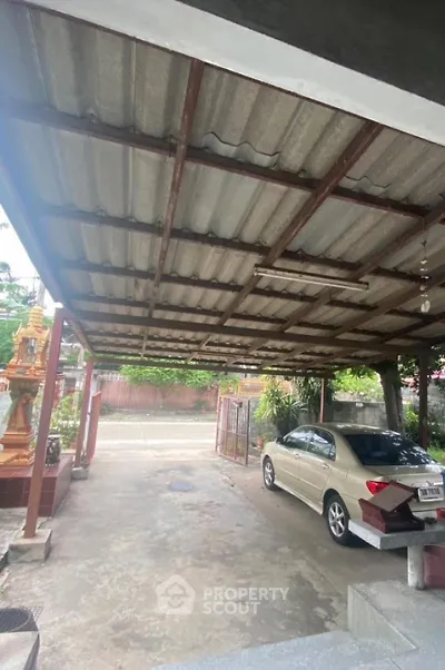 Spacious carport with metal roofing and parked car in residential area