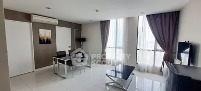 Modern living room with sleek furniture and large windows offering natural light.