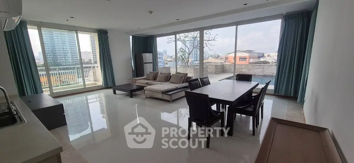 Spacious modern living room with large windows and city view, featuring elegant dining area and comfortable seating.