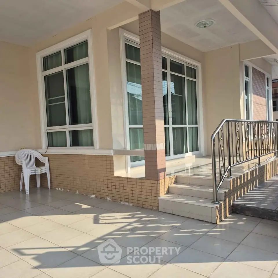 Charming residential entrance with tiled steps and large windows, perfect for welcoming guests.