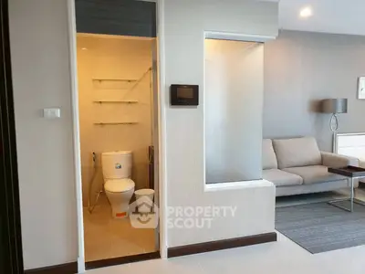 Modern apartment interior with cozy living room and adjacent bathroom
