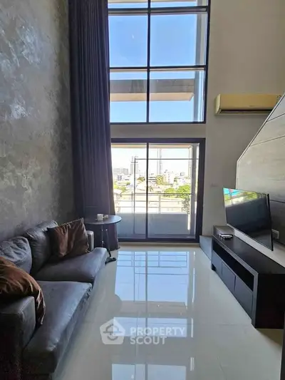 Modern living room with high ceiling and large windows offering city view