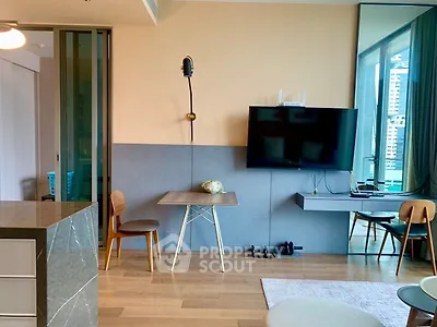 Modern living room with stylish decor and wall-mounted TV in a high-rise apartment.