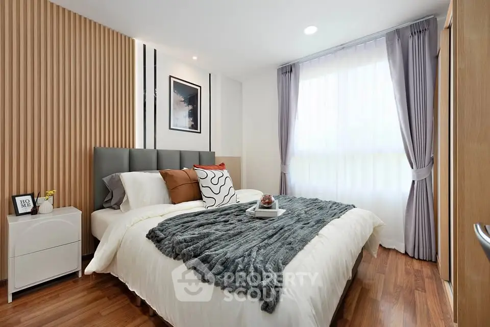 Modern bedroom with stylish decor and natural light, featuring a cozy bed and elegant curtains.