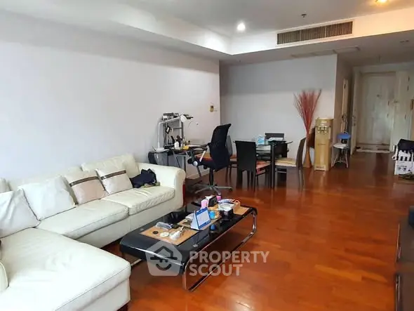 Spacious living room with modern furniture and wooden flooring in a stylish apartment.