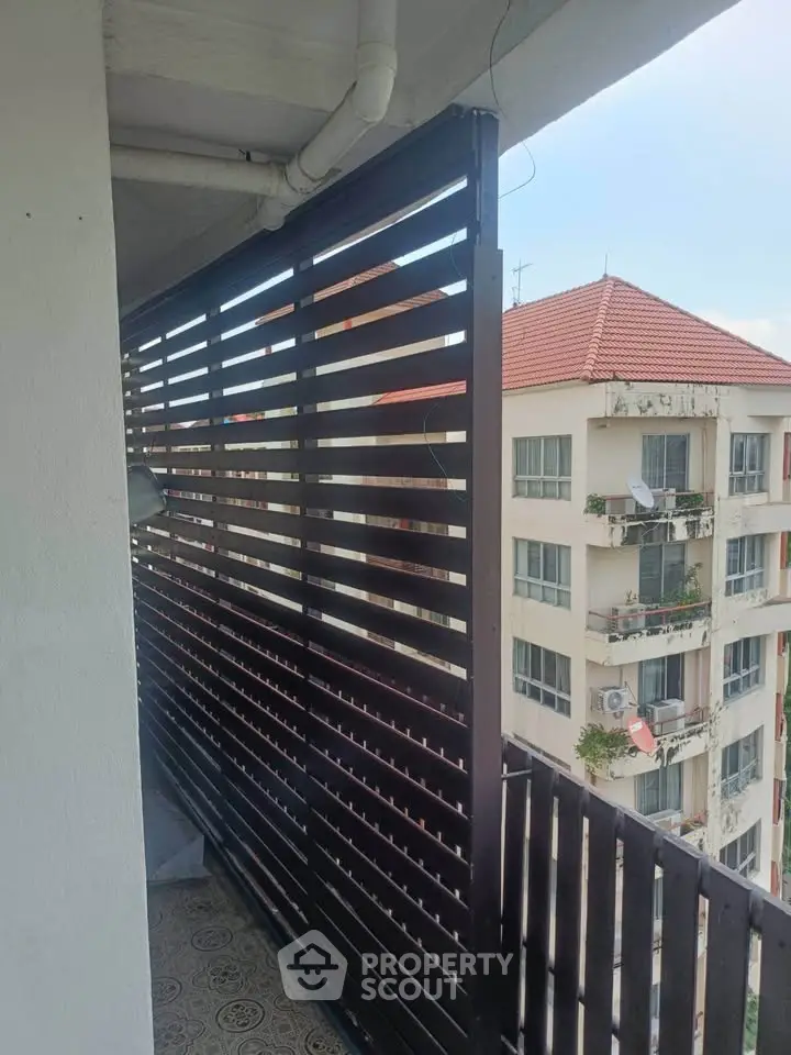 Charming balcony with privacy screen and city view in modern apartment