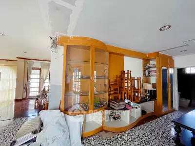 Spacious living room with built-in wooden cabinets and elegant patterned flooring.