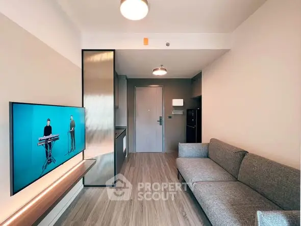 Modern living room with sleek design, featuring a comfortable sofa and wall-mounted TV in a stylish apartment.