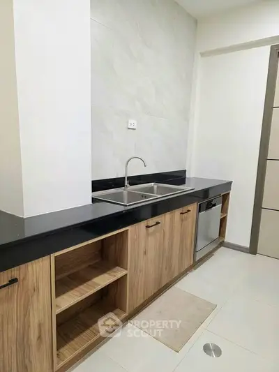 Modern kitchen with sleek black countertops and wooden cabinetry