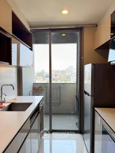 Modern kitchen with sleek appliances and balcony view in urban apartment