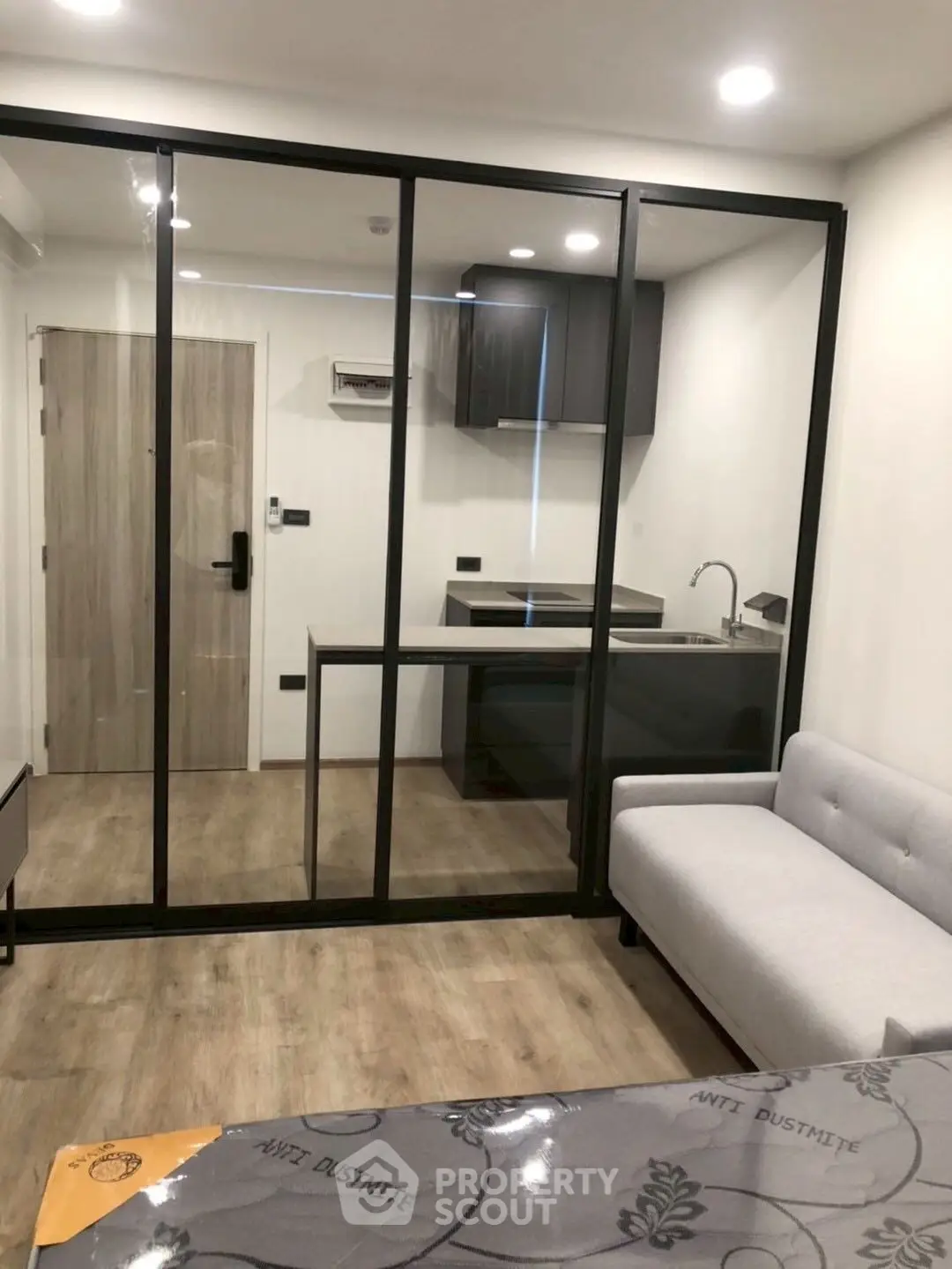 Modern apartment with glass partition and sleek kitchen design
