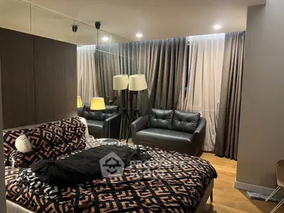 Luxurious bedroom with stylish decor and cozy seating area, perfect for relaxation.