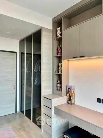 Modern bedroom with built-in wardrobe and study desk, featuring sleek design and ample storage.