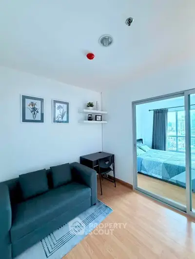 Modern apartment interior with cozy living room and bedroom view, featuring stylish decor and natural light.