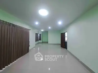 Spacious empty living room with glossy tiled floors and soft lighting