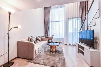 Spacious modern living room with high ceilings and large windows, featuring stylish furniture and a cozy ambiance.