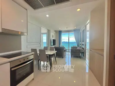Stunning open-plan living room with ocean view, modern kitchen, and elegant dining area.