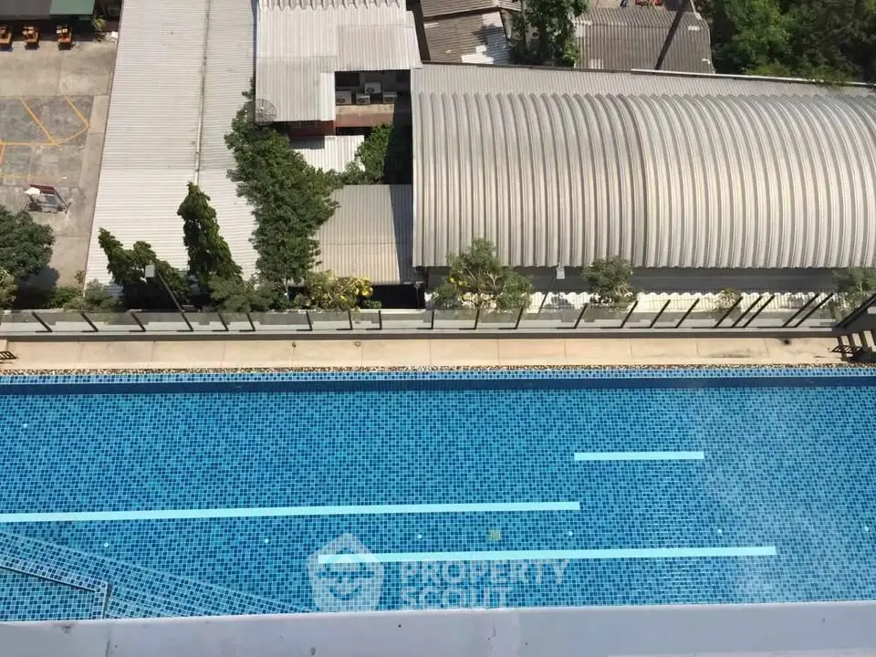 Stunning aerial view of a modern swimming pool with blue mosaic tiles, perfect for relaxation and leisure.