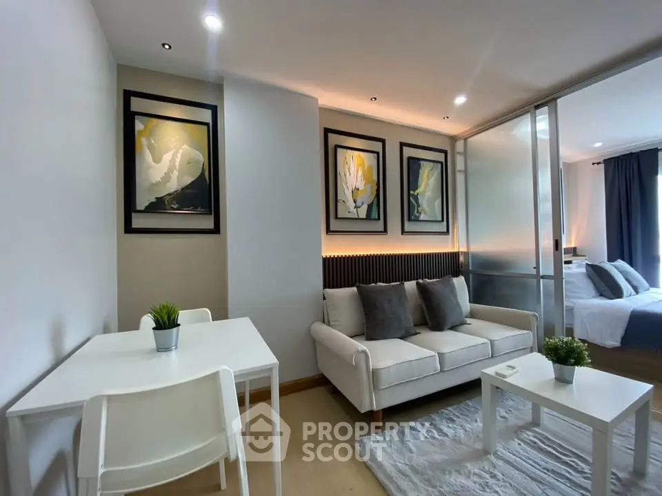 Modern living room with stylish decor and adjacent bedroom view