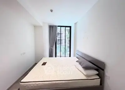 Spacious bedroom with large window and modern decor