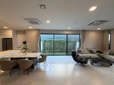 Spacious modern living room with garden view, featuring elegant furniture and open layout.