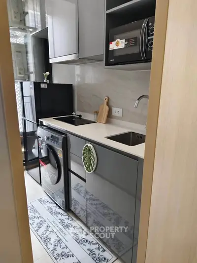Modern kitchen with sleek appliances and stylish cabinetry in a compact layout.
