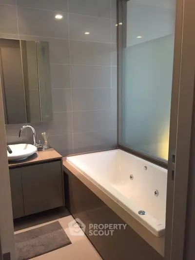 Modern bathroom with sleek bathtub and stylish vanity in contemporary home.