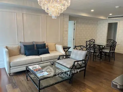 Luxurious living room with elegant chandelier and stylish furniture in modern apartment.