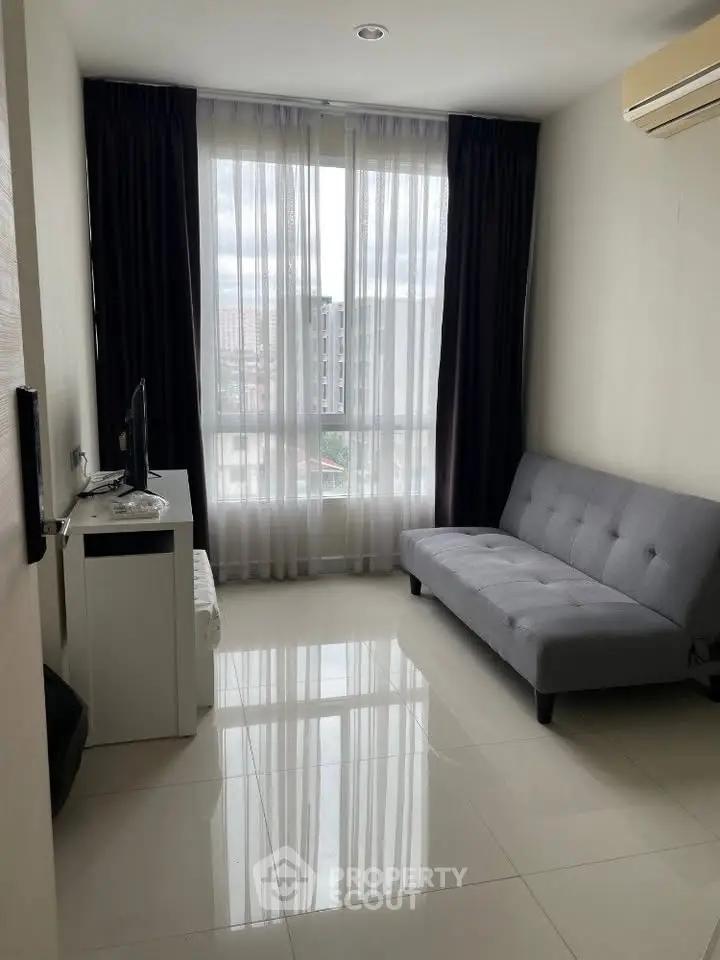 Modern living room with sleek sofa and large window offering city view