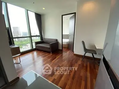 Modern living room with wooden floors and city view in high-rise apartment.