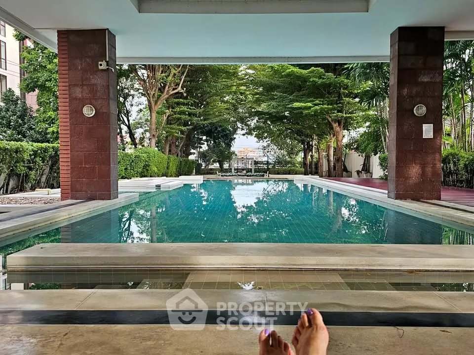 Luxurious poolside view with lush greenery and serene ambiance in a high-end residential complex.