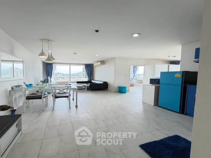 Spacious modern living room with open kitchen and panoramic city view