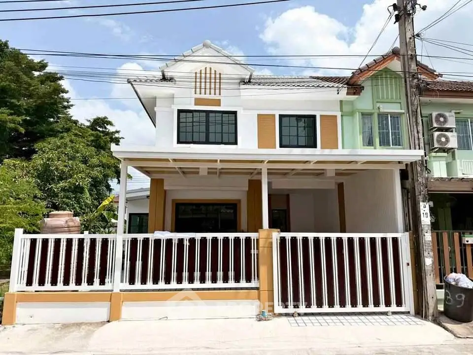 Charming two-story townhouse with modern facade and gated entrance