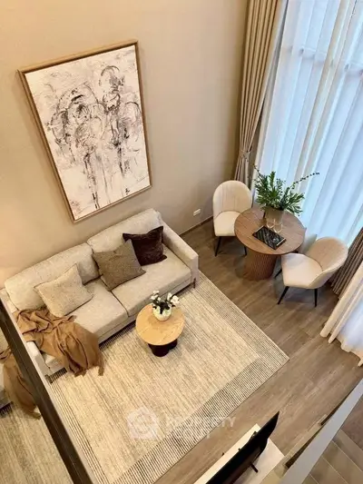 Elegant living room with high ceiling, modern decor, and cozy seating area.
