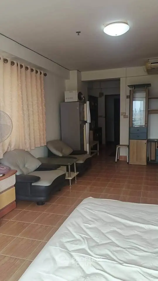 Spacious studio apartment with cozy seating and natural light, ideal for urban living.