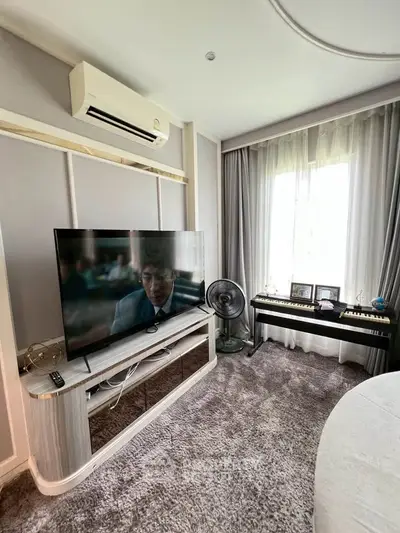Charming living room with modern TV setup and natural light from large window.