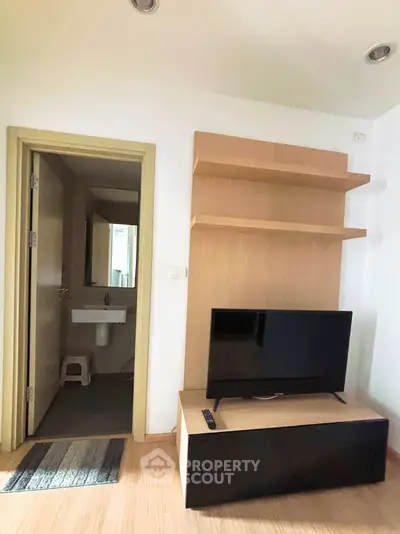Cozy living room with TV and open bathroom view in modern apartment