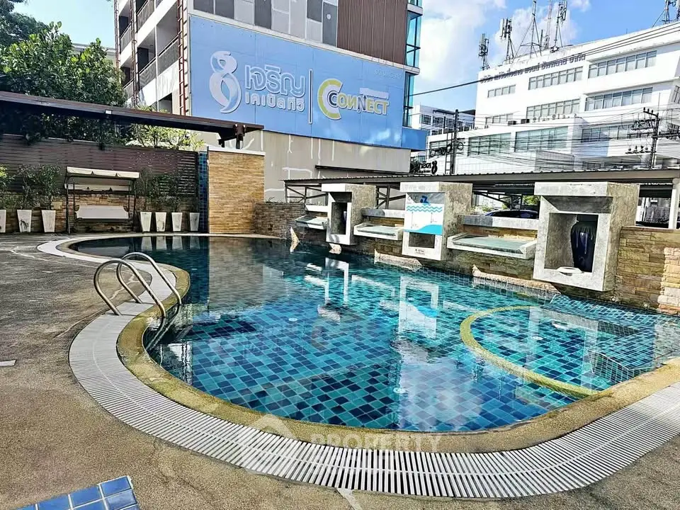 Modern apartment complex with stylish outdoor pool and seating area