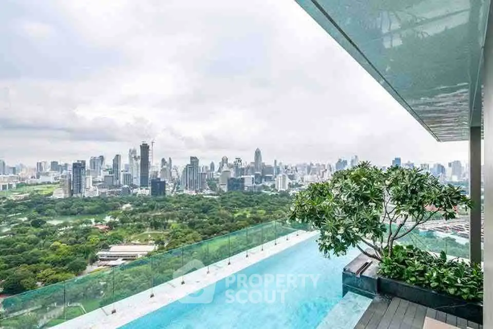 Stunning rooftop pool with panoramic city skyline view and lush greenery.