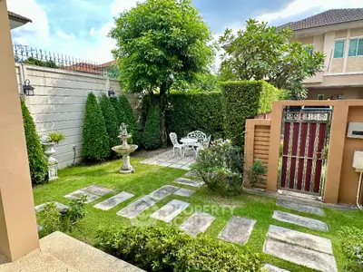 Charming garden with elegant patio furniture and lush greenery in a serene residential setting.