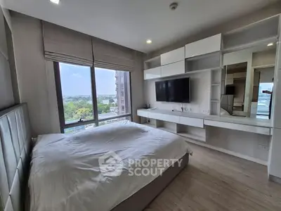 Modern bedroom with large window and built-in storage, offering a serene view.