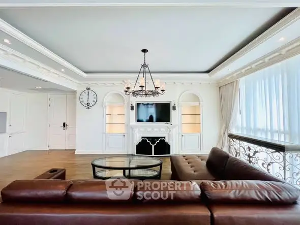 Luxurious living room with elegant chandelier and leather sofa in upscale apartment.