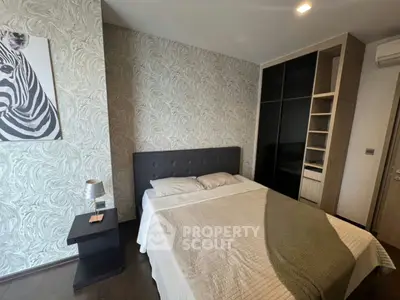 Modern bedroom with stylish wallpaper and cozy bedding in a contemporary apartment.