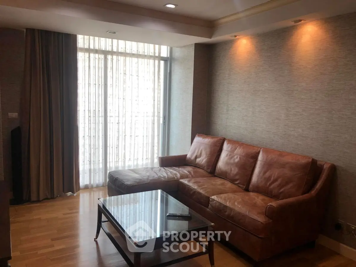 Cozy living room with leather sofa and wooden coffee table, perfect for relaxation.