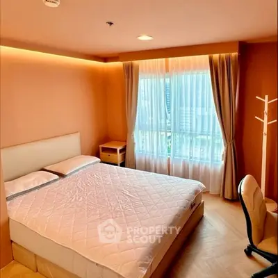 Cozy bedroom with large window and modern furnishings in a stylish apartment.