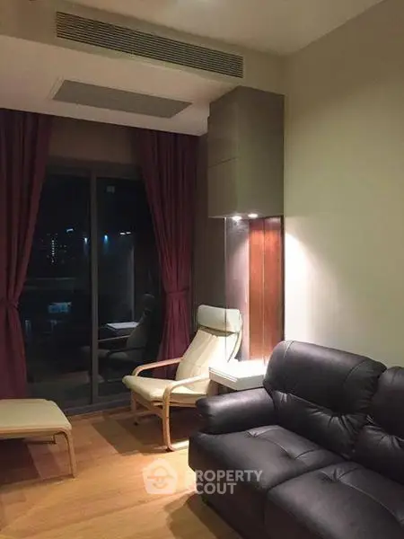 Cozy living room with modern furniture and city view through large window.